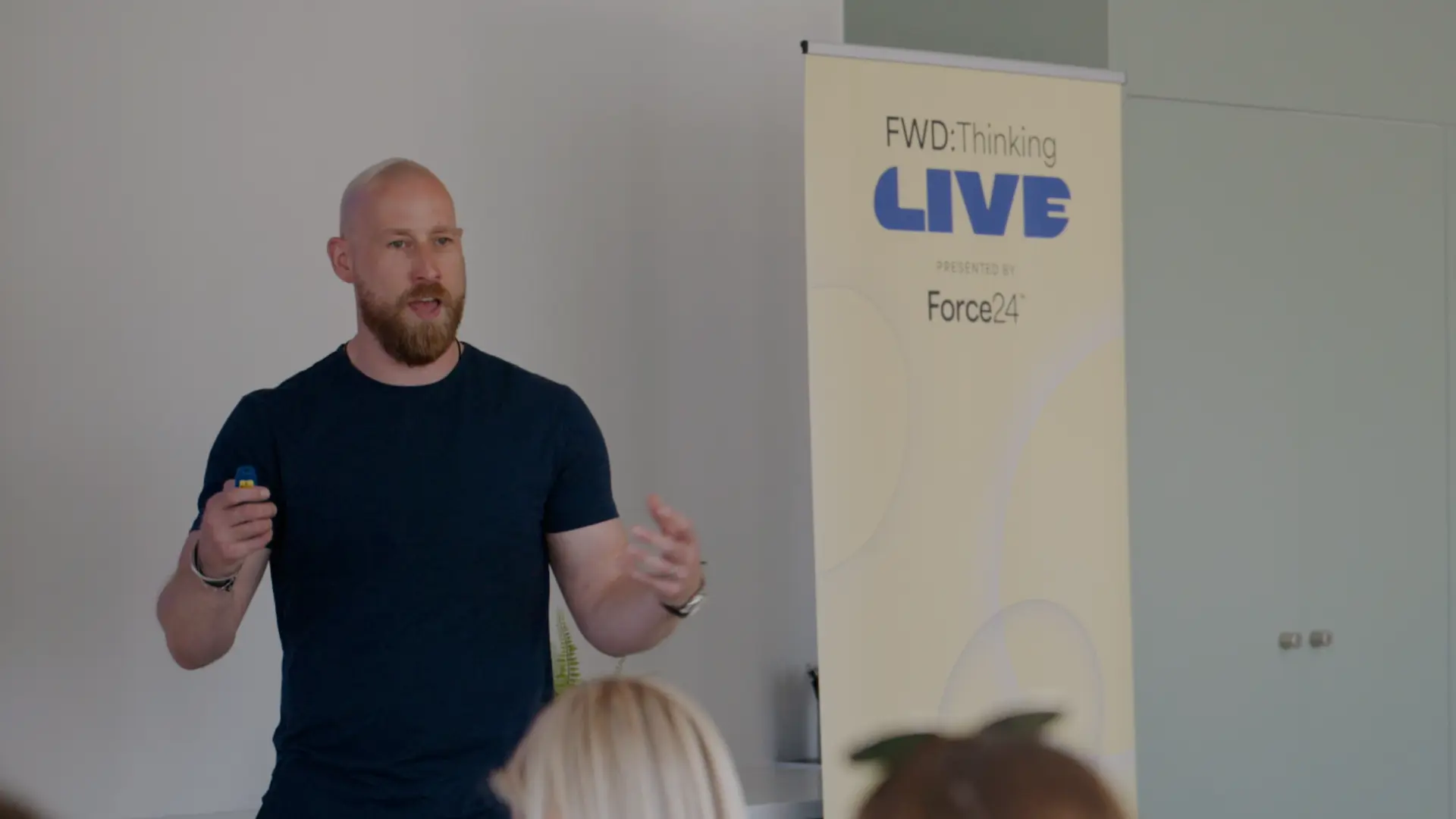 FWDT LIVE speaker presenting to marketers beside the event banner